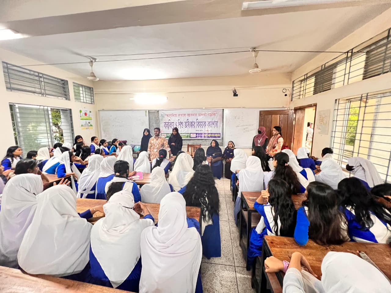 Children raising hands in a classroom during a child rights workshop